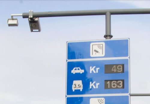 Foto av et skilt som viser veiprisene (bompengetakstene) for personbiler og tunge kjøretøy.