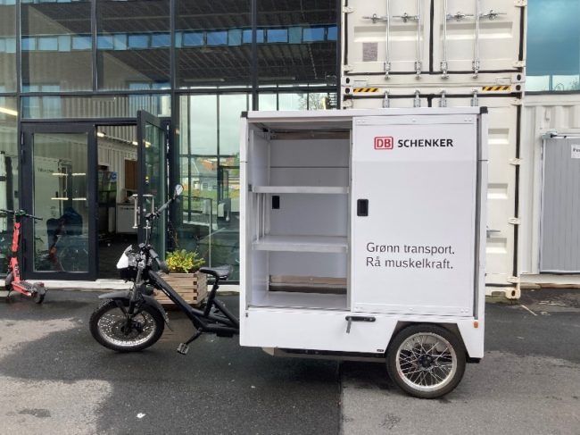 Fotoet viser en lastesykkel som benyttes av DB Schenker. Lasteenheten er &aring;pen s&aring; en ser hyllesystemet inne i lasteenheten.
